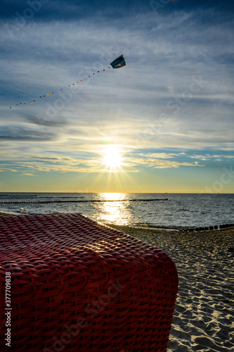 Drachenfliegen im Sonnenuntergang an Strand an der Ostsee