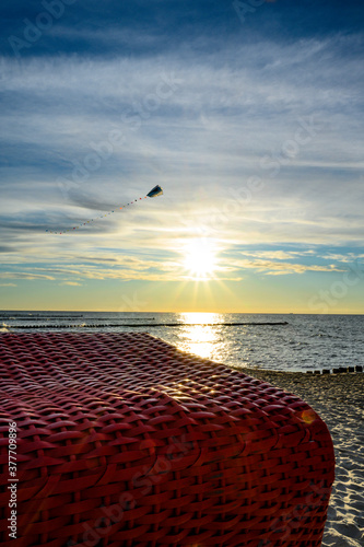 Drachenfliegen im Sonnenuntergang an Strand an der Ostsee