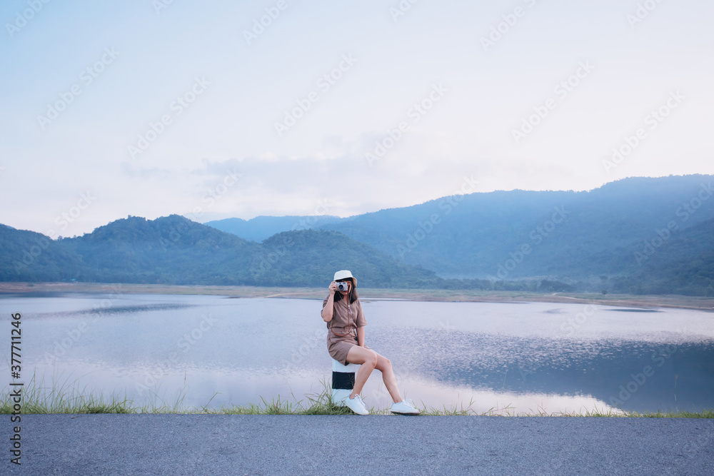 Beautiful young woman sit take photograph while reservoir in Nakorn Nayok, Thailand. Vacation concept Beautiful young woman sit take photograph while reservoir in Nakorn Nayok, Thailand. Vacation concept
