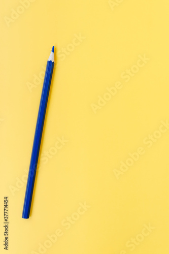 Blue pencil on a yellow background. Stationery. Concept art, education fresh ideas.