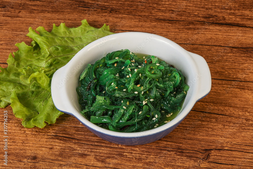 Green Chuka Seaweed Salad Isolated on White Background Top View. Wakame Sea Kelp Salat Green Chuka Seaweed Salad Isolated on White Background Top View. Wakame Sea Kelp Salat