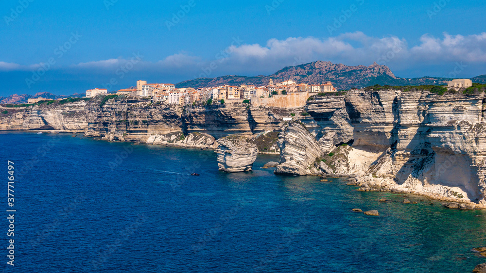 Corsica Bonifacio white cliff with citadel old town facing the Mediterranean Sea during sunny day.