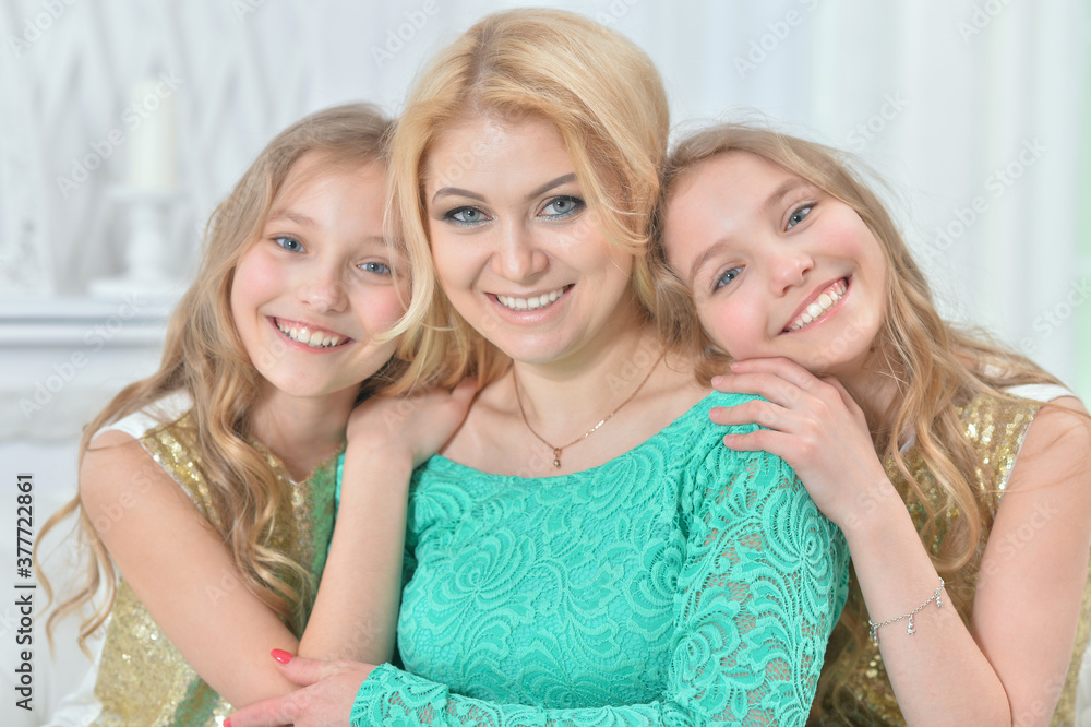Cute smiling twin sisters hugging their mother Cute smiling twin sisters hugging their mother
