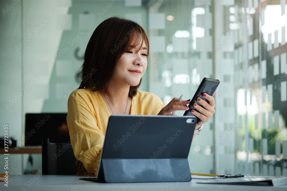 Smiling businesswoman sitting in modern office. and using smart phone. Smiling businesswoman sitting in modern office. and using smart phone.