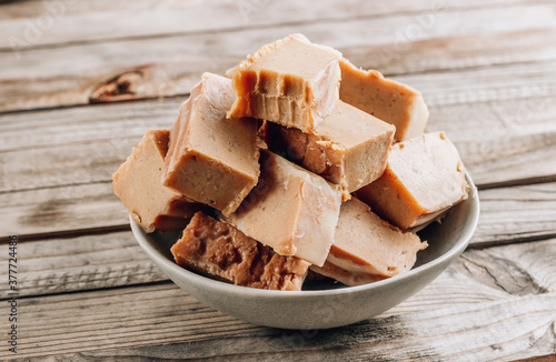 Raw vegan peanut butter fudge on a rustic wooden background.
