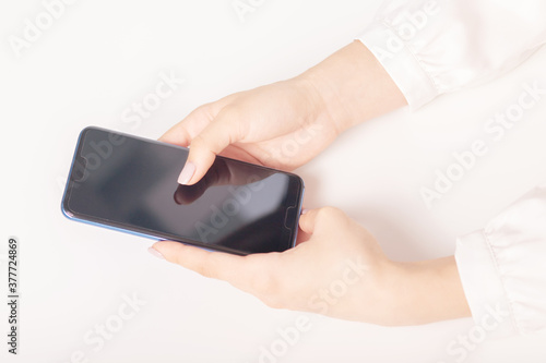 female hands with a smartphone at a table