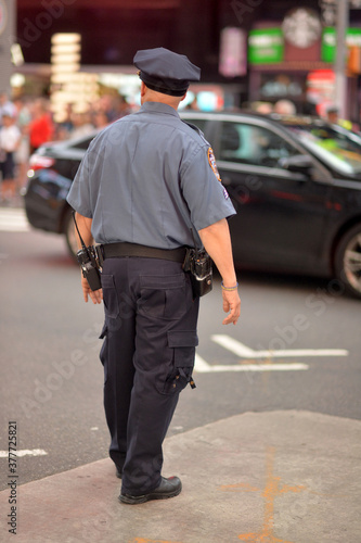 Police officer standing on city street against the background of cars