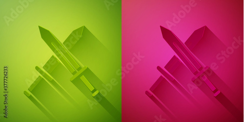 Paper cut Crossed medieval sword icon isolated on green and pink background. Medieval weapon. Paper art style. Vector.