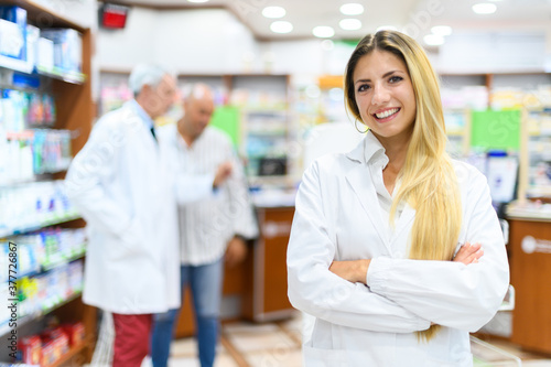 Young female pharmacist smiling in her store