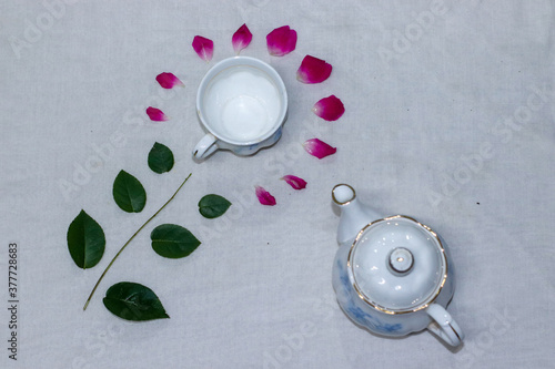 Empty tea and saucer with rose petals