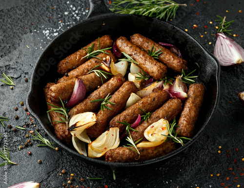 Rosemary and onion vegetarian vegan sausages oven baked in cast iron skillet frying pan photo