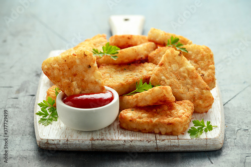 Tableau sur toile Hash brown potato with ketchup on white wooden board