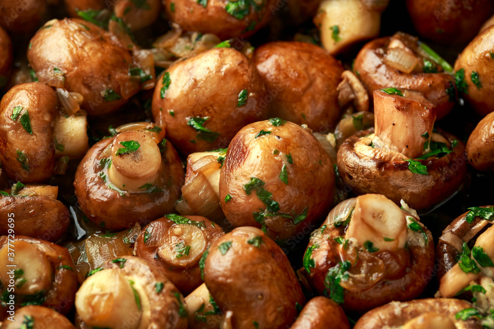 Fried mushrooms with onion and garlic in iron cast pan Fried mushrooms with onion and garlic in iron cast pan