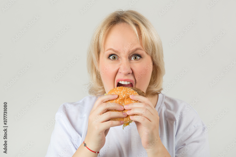 beautiful young plump woman in a white t-shirt on a white background with a hamburger beautiful young plump woman in a white t-shirt on a white background with a hamburger