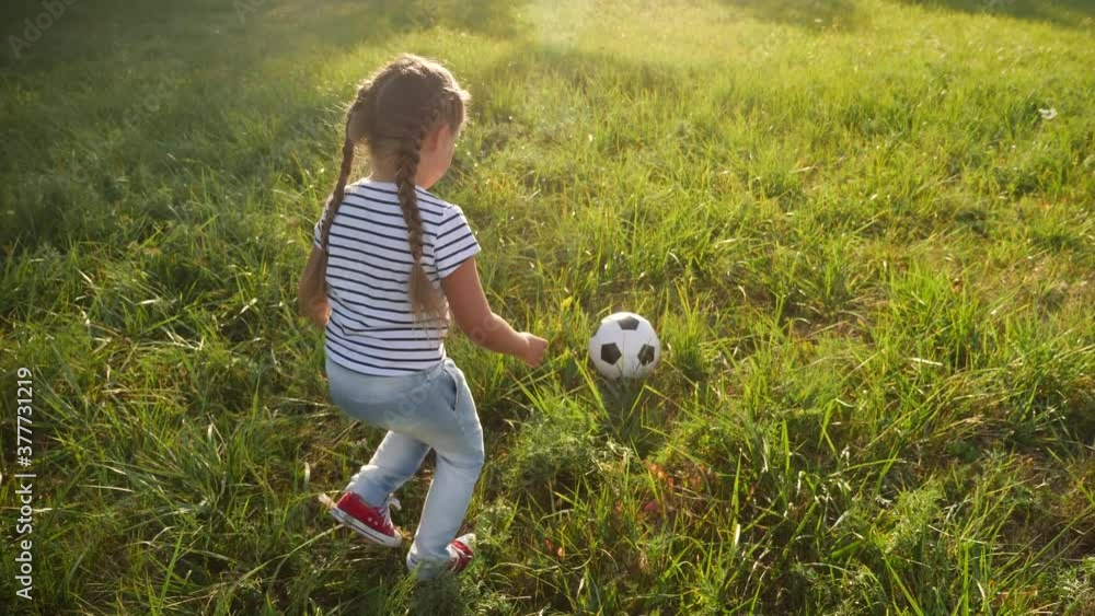 little girl play soccer in the park with a ball. kid dream concept. kid play ball on green grass in the park. child playing soccer. people in the park concept fun little girl play soccer in the park with a ball. kid dream concept. kid play ball on green grass in the park. child playing soccer. people in the park concept fun