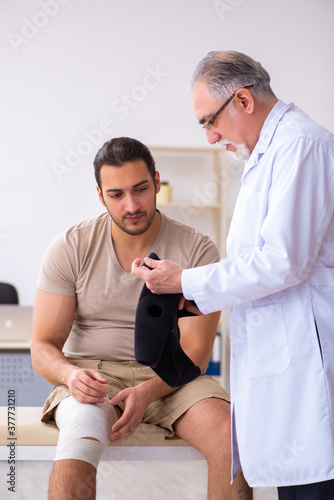 Experienced doctor traumatologist examining young male patient