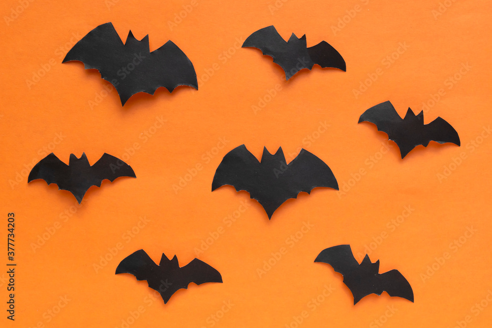 Happy Halloween holiday concept. Halloween decorations, bats on an orange background. The layout of the greeting card Happy Halloween holiday concept. Halloween decorations, bats on an orange background. The layout of the greeting card