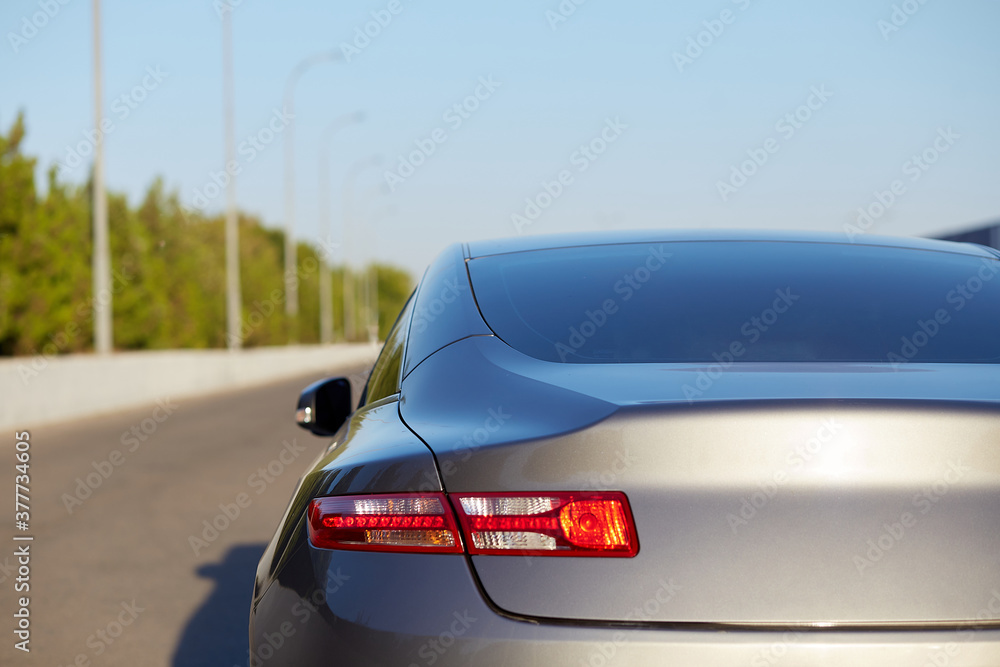 Back window of grey car parked on the street in summer sunny day, rear view. Mock-up for sticker or decals Back window of grey car parked on the street in summer sunny day, rear view. Mock-up for sticker or decals
