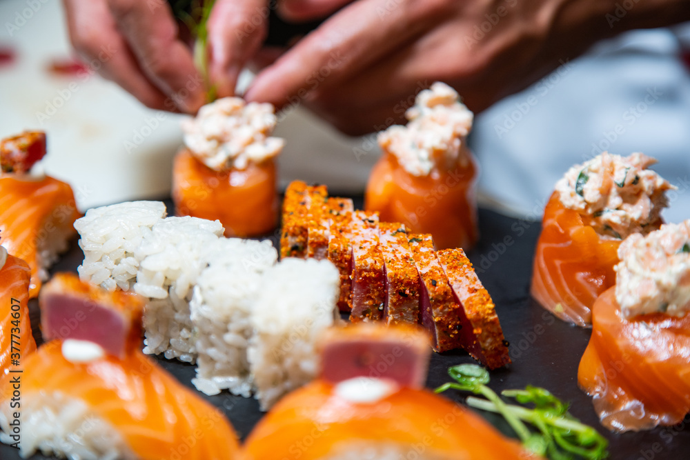 Closeup of chef hands preparing japanese food. Japanese chef making sushi at restaurant.