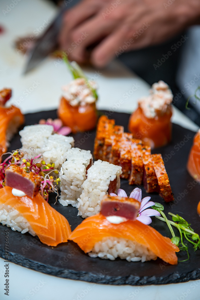 Closeup of chef hands preparing japanese food. Japanese chef making sushi at restaurant.