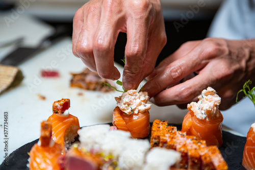 Closeup of chef hands preparing japanese food. Japanese chef making sushi at restaurant. 