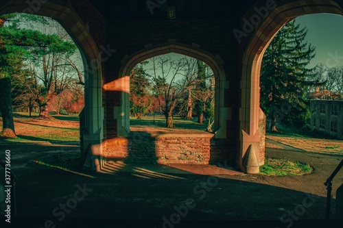 Looking Out at the Driveway Through a Window in a Cobblestone Wall at a Gorgeous View of the Elkins Estate Property photo