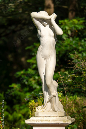 white marble statue of a woman in the park 