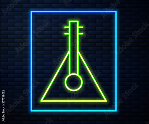 Glowing neon line Musical instrument balalaika icon isolated on brick wall background. Vector.