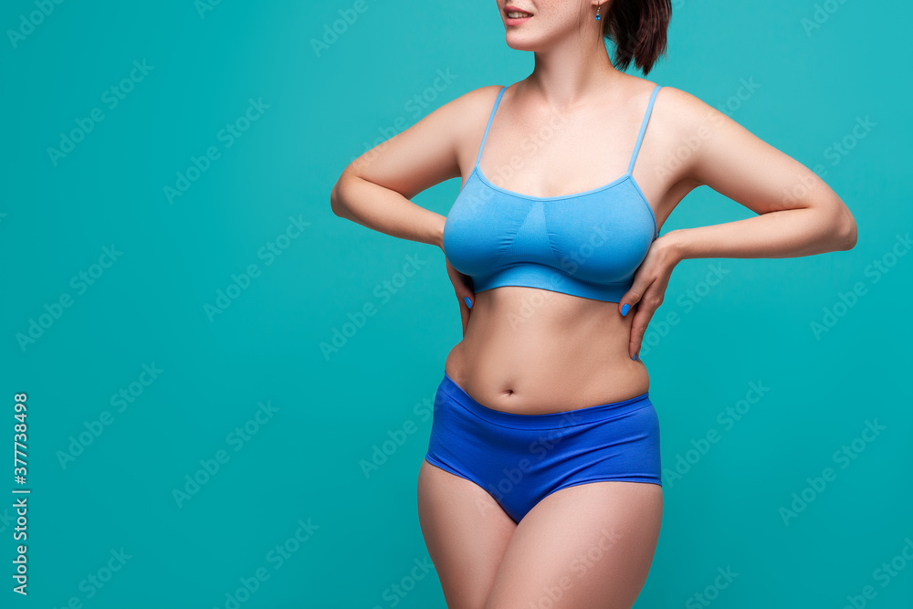 Plus size model in blue underwear on turquoise background Plus size model in blue underwear on turquoise background