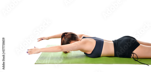 Close up of a woman lying on her stomach on a sports mat and doing exercise.