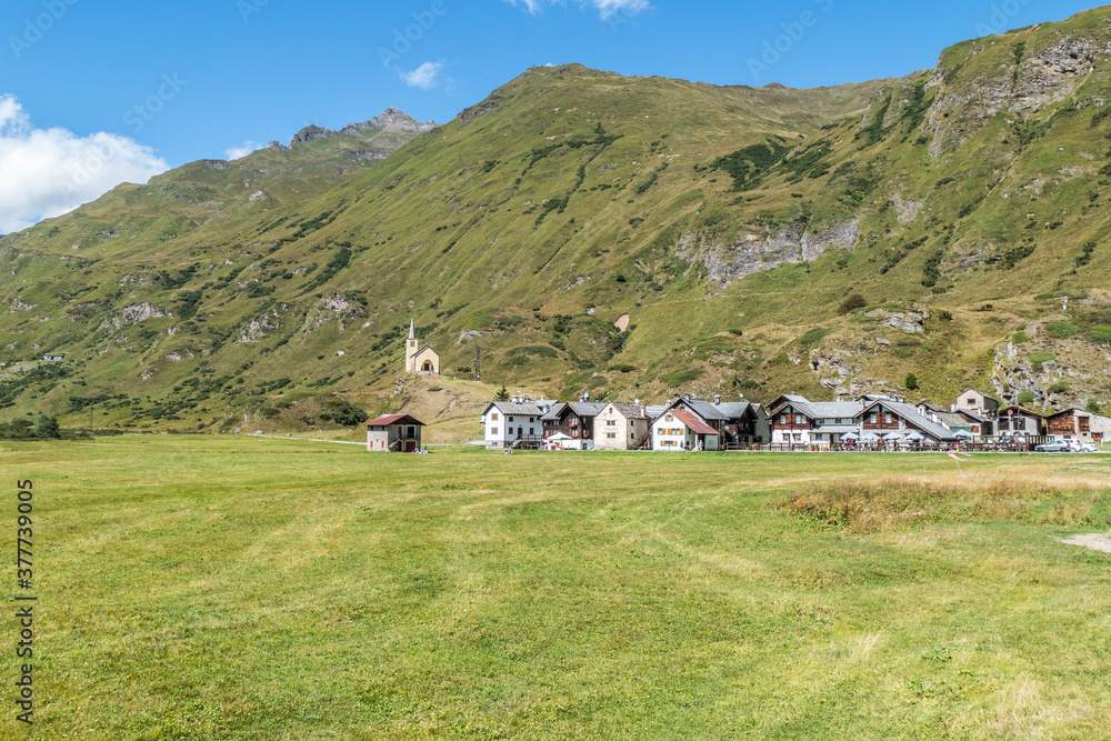 small village in the mountains with stone houses, flowers and a church in val formazza