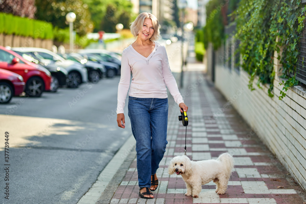 Mature woman walking with a dog outdoors an antivirus mask Mature woman walking with a dog outdoors an antivirus mask