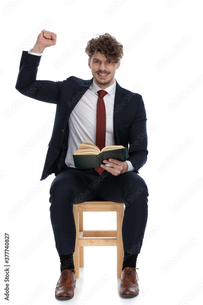 handsome businessman holding his book on his lap handsome businessman holding his book on his lap