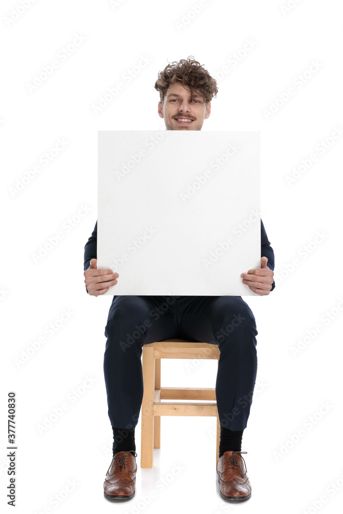 young businessman showing a blank board at the camera young businessman showing a blank board at the camera