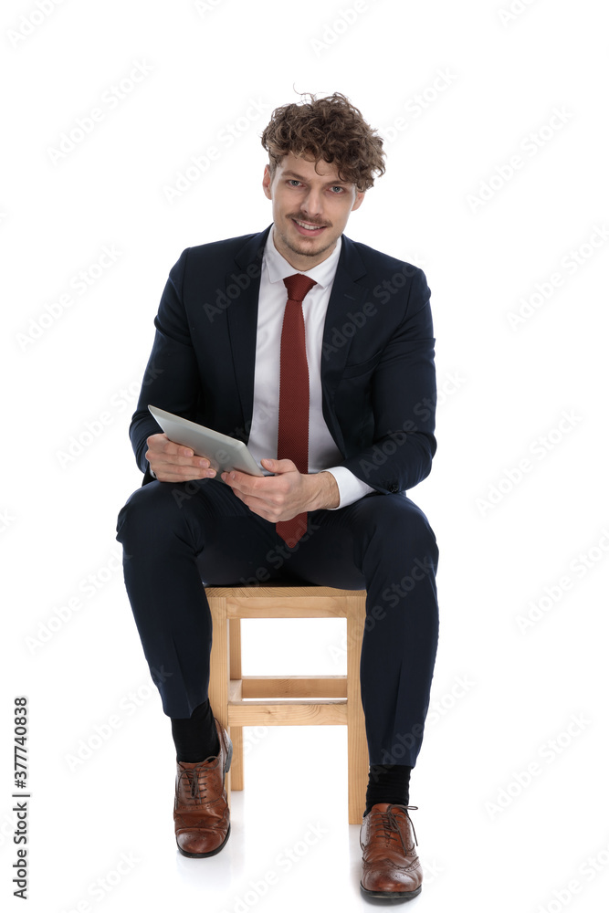 young handsome businessman holding his tablet, smiling at camera young handsome businessman holding his tablet, smiling at camera