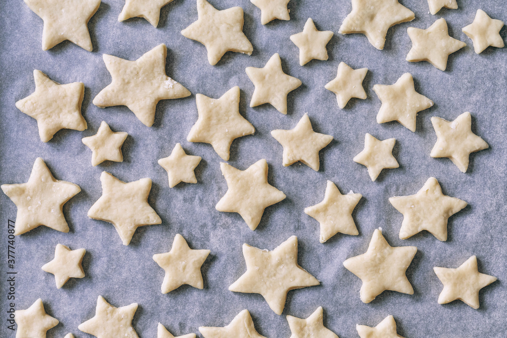 cookies in the form of stars on parchment paper lies in baking tray cookies in the form of stars on parchment paper lies in baking tray