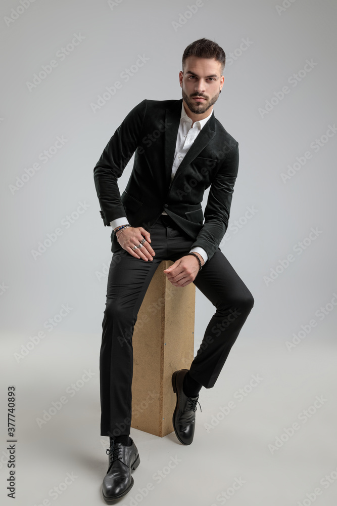 sexy businessman is posing against gray background - obrazy, fototapety, plakaty 
