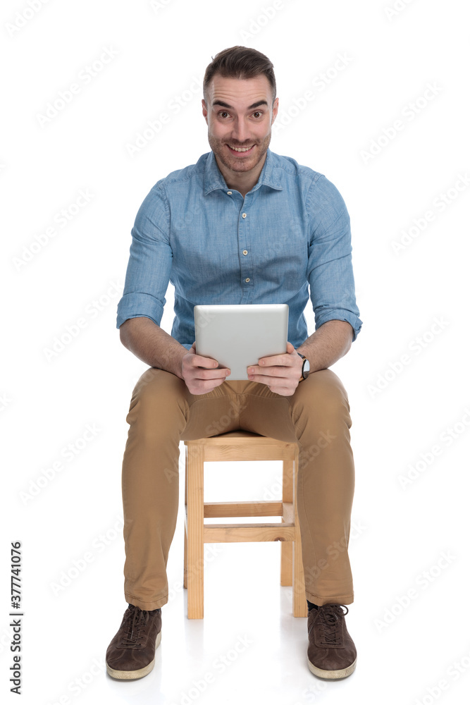 Positive smart casual man smiling and holding tablet Positive smart casual man smiling and holding tablet