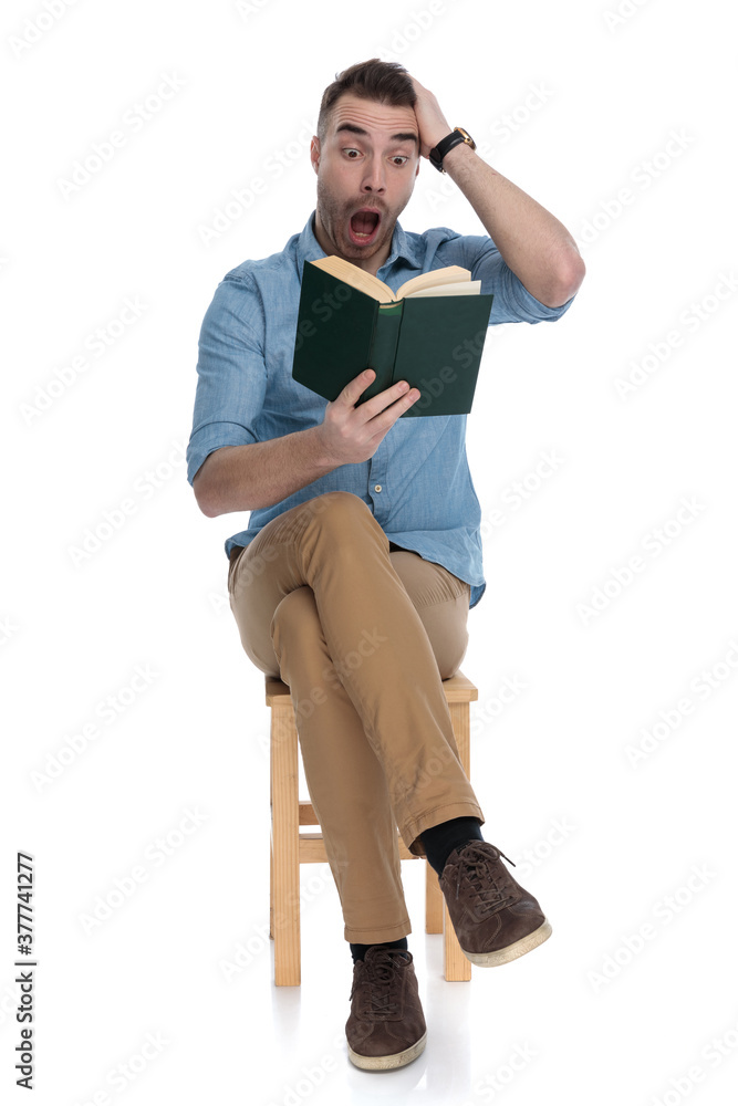 Amazed smart casual man reading a book and shouting, Amazed smart casual man reading a book and shouting,