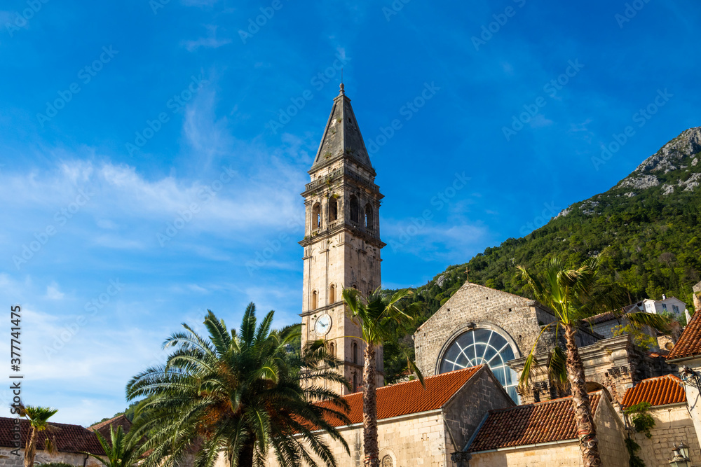 The bright beautiful landscape of Perast against the background of mountains in the summer on a clear day, city on the shores of the Adriatic Sea