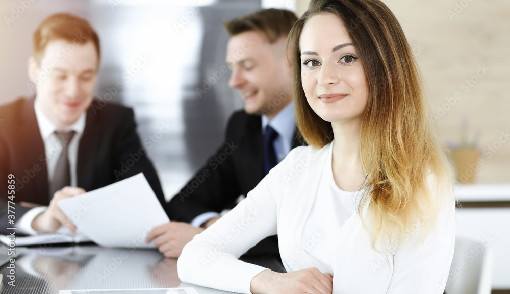 Business woman headshot in sunny office. Unknown businesswoman sitting behind computer monitor Business woman headshot in sunny office. Unknown businesswoman sitting behind computer monitor