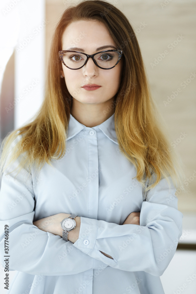 Business woman headshot in sunny office. Unknown businesswoman standing straight with tablet computer. Young accountant or secretary looks good Business woman headshot in sunny office. Unknown businesswoman standing straight with tablet computer. Young accountant or secretary looks good
