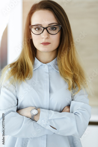 Business woman headshot in sunny office. Unknown businesswoman standing straight with tablet computer. Young accountant or secretary looks good