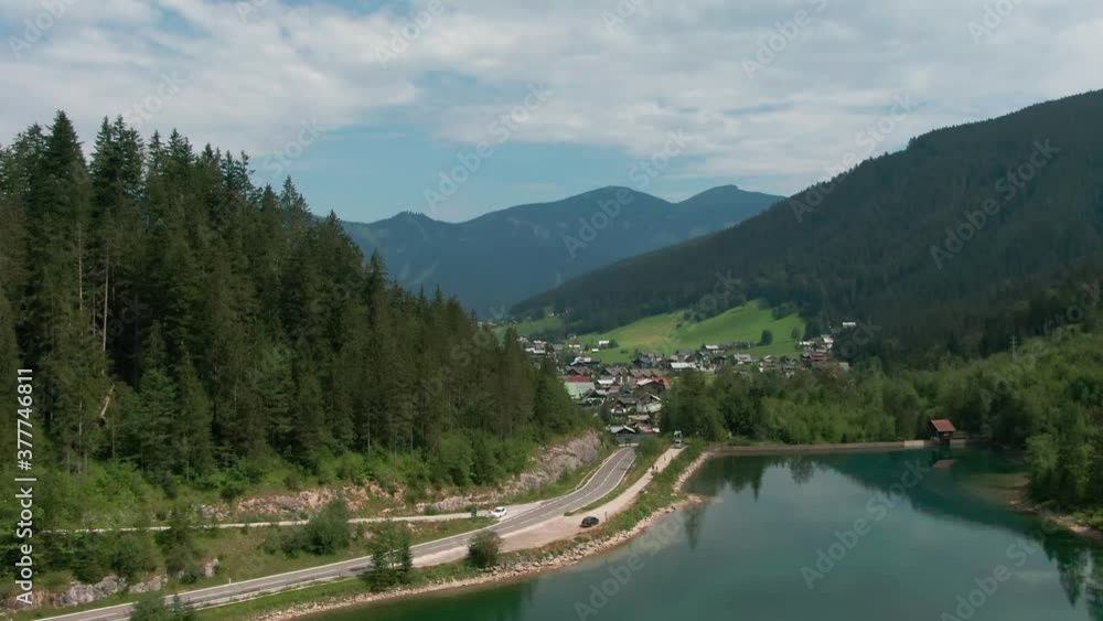aerial view of Gosau in Austria behind trees and lake and mountains in the back aerial view of Gosau in Austria behind trees and lake and mountains in the back