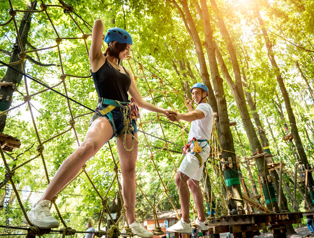 Obraz premium Young couple having fun time in adventure rope park.
