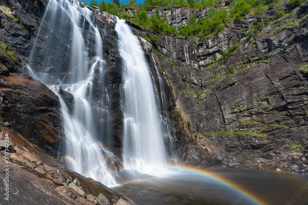 Fototapeta premium Skjervsfossen waterfall, on the road between Granvin and Voss, Hordaland, Norway. Impressive beautiful win falls plunging 150 metres in a narrow canyon