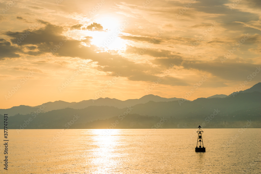 Lonely buoy lighthouse in the sea against the backdrop of picturesque mountains