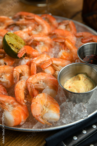 Boiled shrimp from the menu of an American restaurant. On a wooden table 