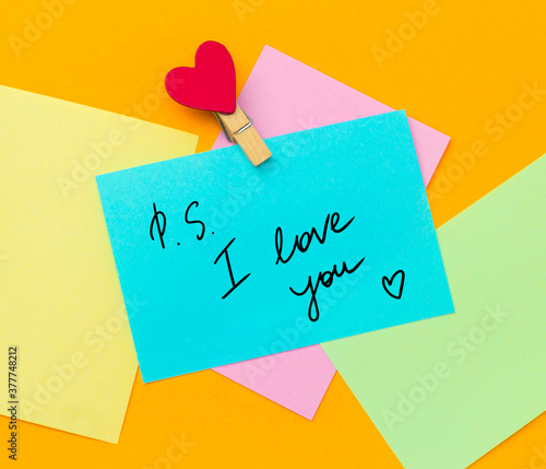 multicolored paper notes with text ps i love you  with cloth pin decorated with red heart photo