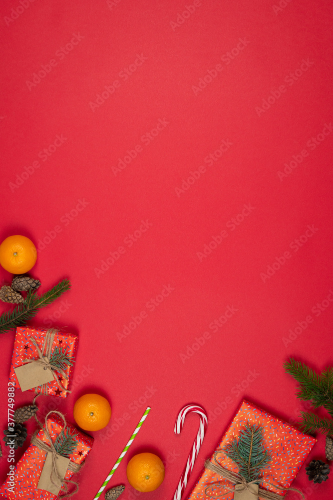 New Year and Christmas presents, handmade gift boxes wrapped with red paper and decorated fir tree branches, flat lay, red background. Copy space. Concepts of greeting card. Top view.